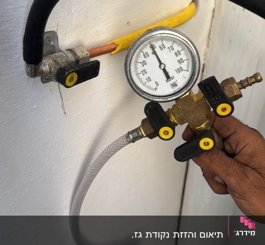 מד לחץ גז מחובר לצינור עם ידית כיוון